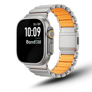 Porto Armband mit titanfarbenen Gliedern und orangefarbener Silikoninnenseite an einer Apple Watch - schräge Vorderansicht